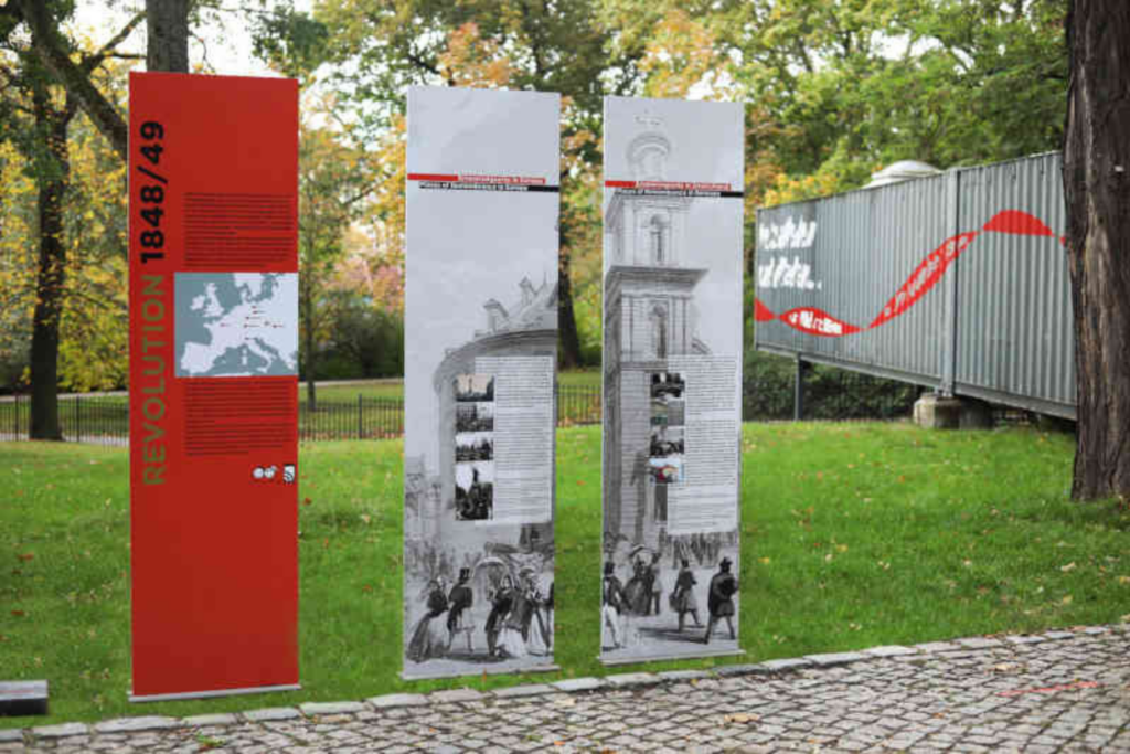 Dauerausstellung der Revolution 1848, Tafeln mit Informationen im Außenbereich vor einem Ausstellungscontainer, forum 1848 am Friedhof der Märzgefallenen