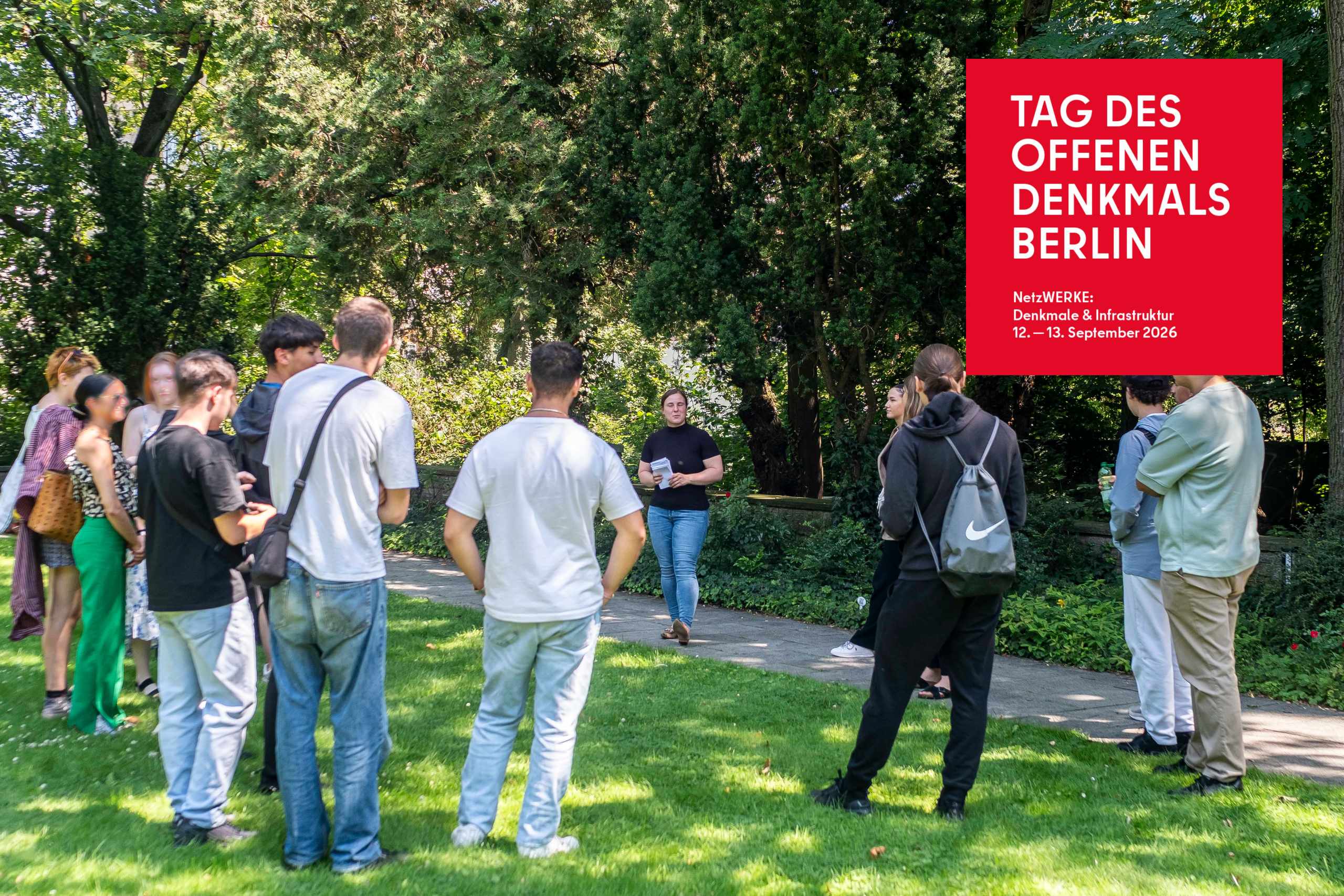 Eine Frau gibt eine Führung auf dem friedhof der Märzgefallenen, im Hintergrund Grün.